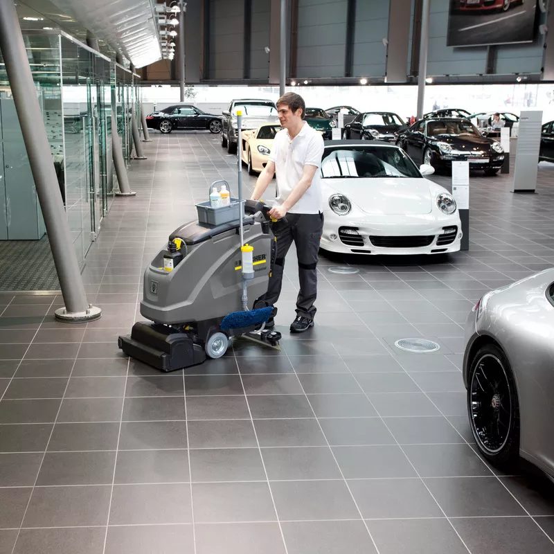 Automatic floor scrubber cleaning a car dealership showroom floor