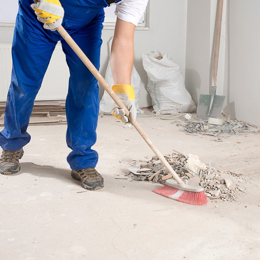 Crew sweeping debris in an industrial space